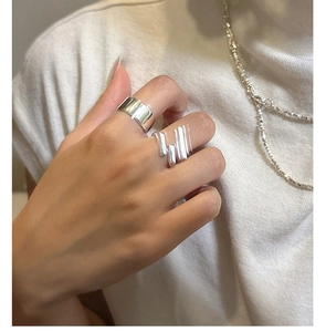 Macro shot of minimalist S925 silver layered rings set worn on a model finger