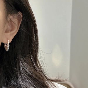 Boucles d'oreilles cœur en argent S925 avec texture martelée portées sur le modèle