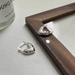 Boucles d'oreilles cœur en argent S925 avec finition martelée sur cuir blanc
