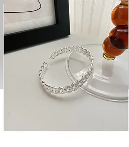Detailed macro view of S925 sterling silver woven Cuban chain texture on an open bangle