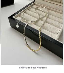 Detail of silver and gold mixed color bead necklace with heart pendant extension