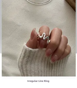 Gros plan d'une bague vague minimaliste en argent S925 portée au doigt pour un look chic