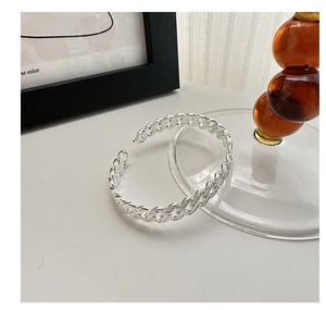 Detail of S925 sterling silver open bangle with classic woven Cuban link texture