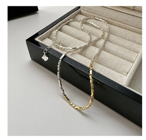 Detail of S925 silver beaded bracelet with heart charm on a beige velvet jewelry tray