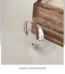 Macro detail of minimalist S925 sterling silver cuff with irregular wavy polished finish