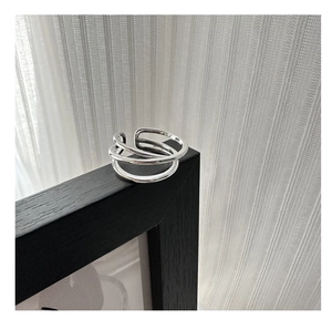 Close-up of a minimalist S925 sterling silver multilayer overlapping ring on a dark frame