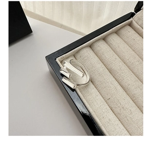 Macro shot of minimalist silver S925 multilayered triple band ring on beige jewelry box