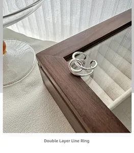 Gros plan d'une bague double couche en argent sterling S925 sur une boîte en noyer