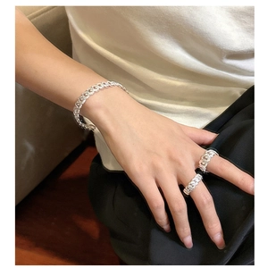 Detail shot of textured S925 sterling silver Cuban link bracelet and ring set on wrist