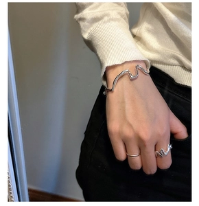 Ensemble bracelet et bague en argent poli à texture ondulée sur une manche en maille