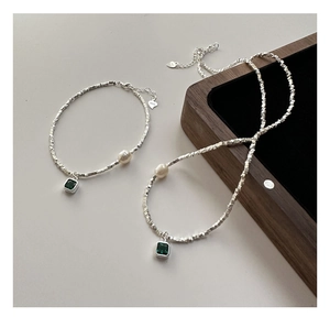 Détail macro du parure en argent S925 avec pierres d'émeraude et perles fines