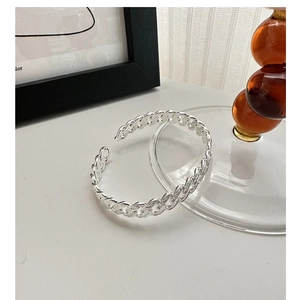 Macro detail of S925 sterling silver cuff bracelet featuring a textured Cuban link pattern