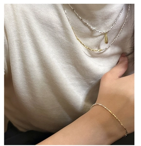 Detailed view of layered S925 silver and gold necklace with mirror water drop pendant