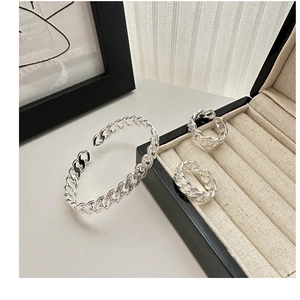 Detailed close-up of woven S925 sterling silver twist ring with polished metal finish