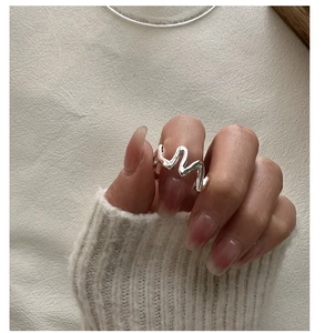 Vue détaillée d'une bague vague en argent S925 poli portée avec style minimaliste