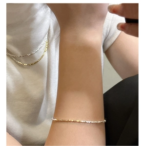 Detail of silver and gold faceted bead necklace and bracelet set with glitter texture