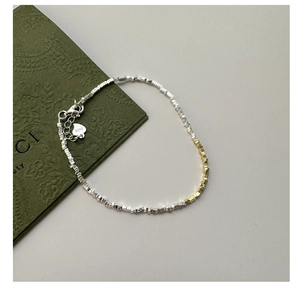 Detail view of faceted S925 sterling silver beads in gold and silver mix with heart charm