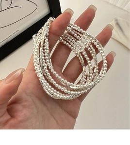 Close-up of double-layer S925 silver beaded necklace with white pearls on hand