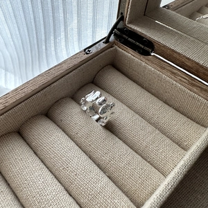 Minimalist S925 sterling silver ring featuring modern liquid lava texture on wood box