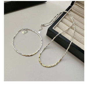 Macro view of S925 sterling silver necklace and bracelet with silver and gold square beads