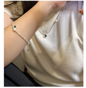 Détail d'un ensemble collier et bracelet en argent avec perles et gemmes vertes