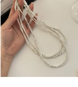Detail of layered S925 sterling silver bracelet with textured beads and white pearls