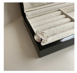 Macro shot of wide S925 sterling silver ring with irregular wave edges in jewelry box