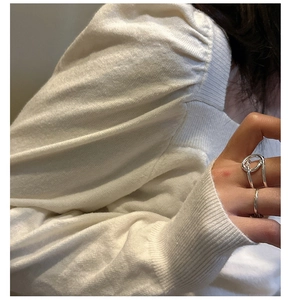 Vue détaillée de bagues en argent sterling S925 portées sur doigt sur tricot blanc
