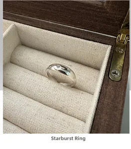Close-up of a 925 sterling silver star ring with diamond in a luxury wooden box