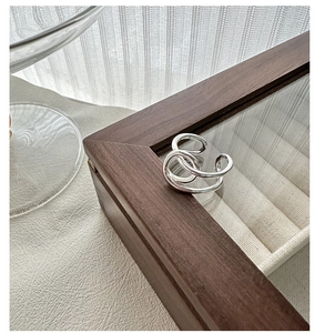 Vue détaillée d'une bague multicouche en argent minimaliste sur un écrin en bois foncé