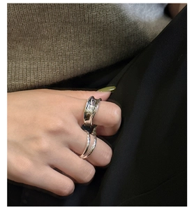 Close-up of stacked S925 sterling silver minimalist rings with irregular wave texture