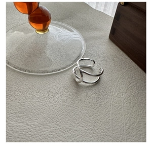 Détail d'une bague en argent sterling S925 au design minimaliste de lignes entrelacées
