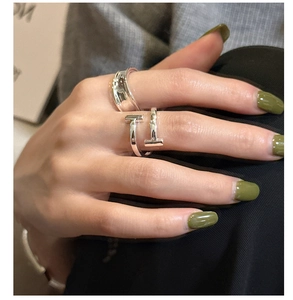 Close-up of S925 sterling silver T-shaped ring and wide hammered band on female fingers