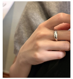 Detailed view of polished silver ring with engraved star pattern on a finger