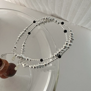 Detail of S925 sterling silver beaded bracelet with black agate and engraved oval tag