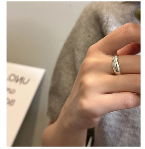 Close-up of 925 sterling silver star engraved ring worn on finger with soft lighting