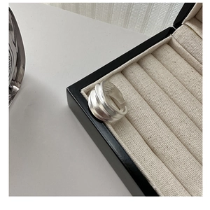 Vue détaillée d'une bague large à vagues en argent S925 mat dans son écrin à bijoux