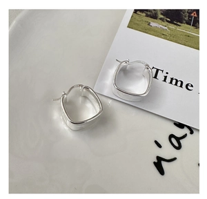 Detailed view of square silver earrings with S925 hallmark on a white ceramic tray