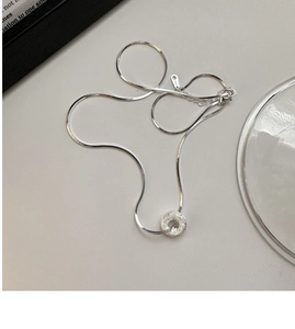 Macro detail of S925 sterling silver frosted donut pendant on a sleek snake chain necklace