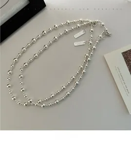 Détail du bracelet en argent S925 avec perles dégradées et étiquettes métalliques