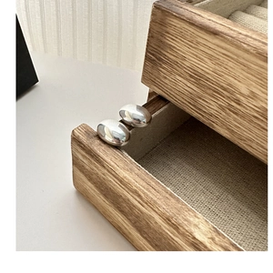 Close-up of oval S925 sterling silver stud earrings with a high-polished mirror finish