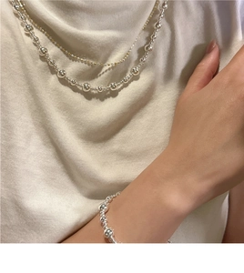 Ensemble collier et bracelet à billes superposés en argent S925 porté par un mannequin