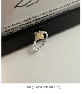 Detail of S925 silver twisted rope ring with golden arabesque clover pattern