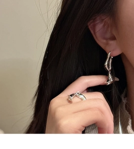 Detailed close-up of S925 sterling silver lily of the valley earrings and ring on a model