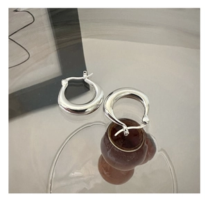 Detail of S925 sterling silver U-shaped hoop earrings with polished mirror finish and 925 stamp