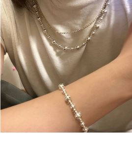 Détail de l'ensemble collier et bracelet à billes en argent S925 sur un mannequin