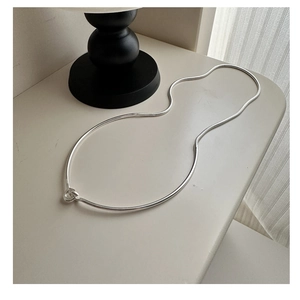 Close-up of S925 sterling silver snake chain necklace with central knot detail