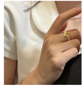 Detailed shot of silver beaded ring band with a golden textured clover-shaped centerpiece