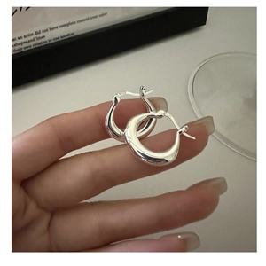 Macro view of S925 sterling silver U-shaped earrings showing the hallmark and smooth finish