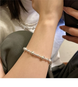 Gros plan d'un bracelet en argent S925 perlé avec chaîne réglable porté au poignet